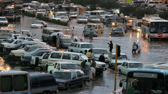 Muslim pilgrims wade across a flooded street in Mena, near Mecca, January 22, 2005. Muslim pilgrims performed final rites of the haj on Saturday, with many praising its safety following fears of stampedes or al Qaeda strikes. More than 2.5 million people took part in this year's haj, which was marred last year by a stampede that killed 250 people at a stoning ritual in the narrow Mena valley near Mecca. REUTERS/Zainal Abd Halim ZH/DL